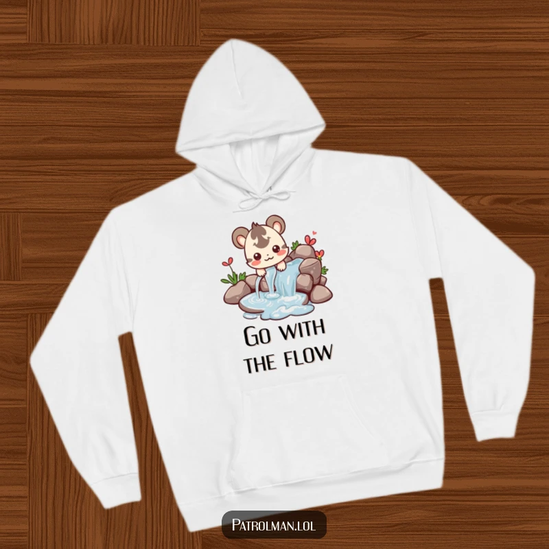Funny hoodie with a happy creature directing a stream of water, radiating peaceful control and fun.
